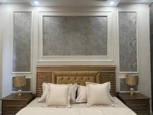 a bedroom with a bed with two nightstands and a painting at Premium 2 bed room apartment in Lahore