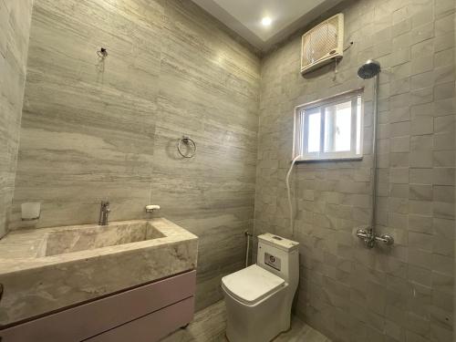 a bathroom with a tub and a toilet and a sink at Premium 2 bed room apartment in Lahore