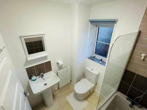 a white bathroom with a toilet and a sink at Balne Mill Grove in Wakefield