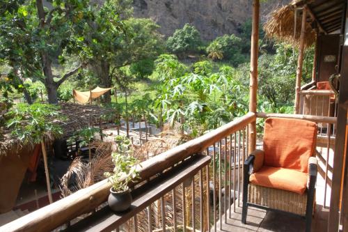 an orange chair sitting on a porch with a garden at Eco Lodge ZEN GARDEN in Paul