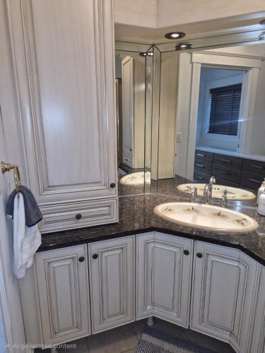 a bathroom with two sinks and a large mirror at Charming Condo - Pool, Minutes to Beach in Pompano Beach