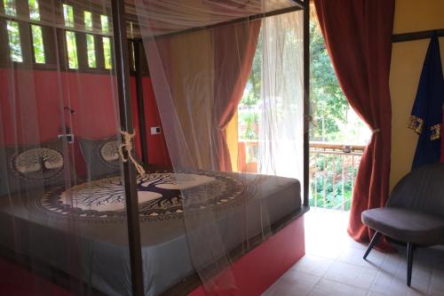 a canopy bed in a room with a window at Eco Lodge ZEN GARDEN in Paul