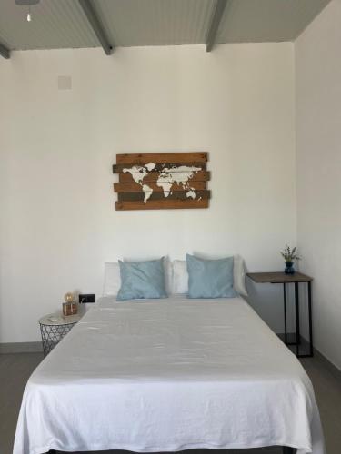 a bedroom with a white bed with blue pillows at Habitación Manzanilla in Sanlúcar de Barrameda