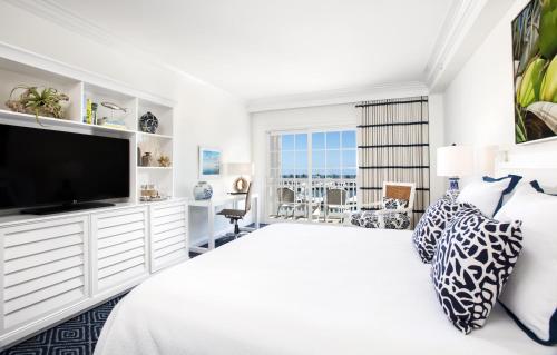 a white bedroom with a large bed and a flat screen tv at Hilton Key West Resort & Marina in Key West