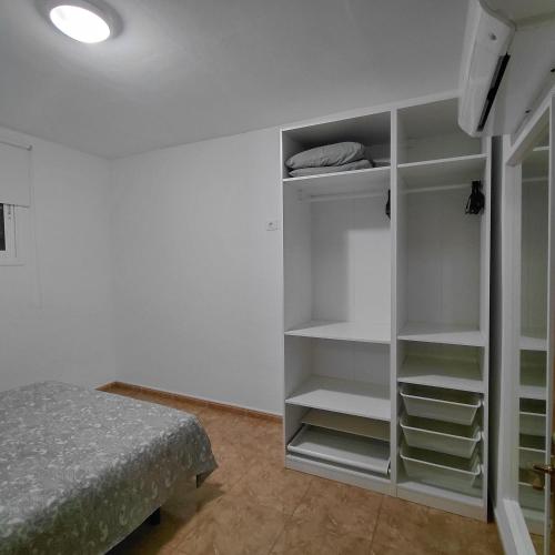 a bedroom with a bed and white shelves at My Little Bungalow in Palm-Mar