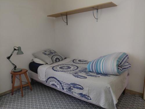 a bedroom with a bed with a lamp on it at Chambre sous les toits in Baule