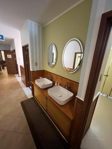 a bathroom with two sinks and two mirrors at Shika Lodge Izu in Ito