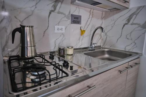 a kitchen counter with a stove and a sink at Poblado-Aguacatala Apart-Hotel in Envigado