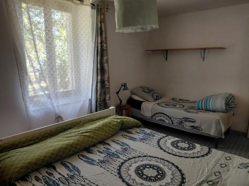 a bedroom with two beds and a window at Chambre sous les toits in Baule