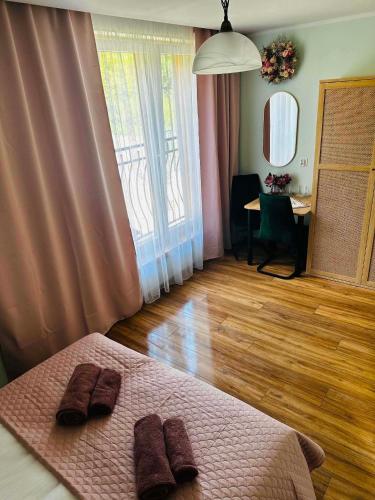 a bedroom with a bed with two brown slippers on it at Pienińska Róża in Szczawnica