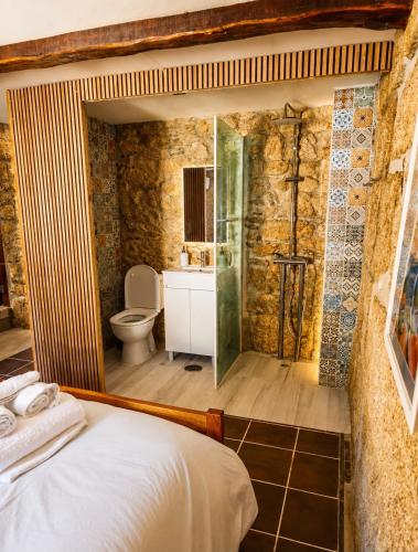 a bathroom with a bed and a shower and a toilet at New Riyork Sweet Home in Geres