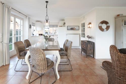 a dining room with a table and chairs at Haus Amrumblick in Hedehusum