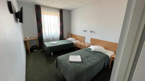 a hotel room with two beds and a window at Zemgale in Jelgava