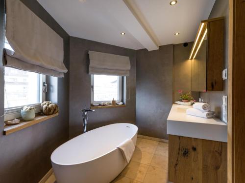 a bathroom with a white tub and a sink at Premium Mountain View Suite in Kirchberg in Tirol