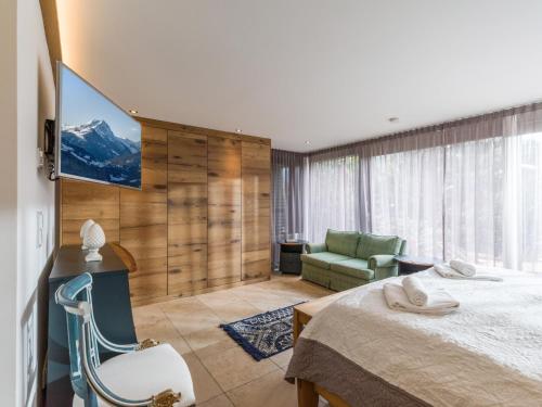 a bedroom with a bed and a couch and a television at Garten Suite mit 2 separaten Studios in Kirchberg in Tirol