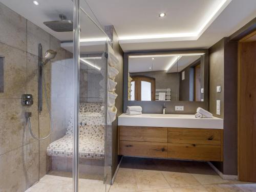 a bathroom with a shower and a sink and a mirror at Garten Suite mit 2 separaten Studios in Kirchberg in Tirol
