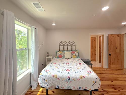 a bedroom with a bed and a window at -NEW- Spring Wish - Historical Loop Home- in Eureka Springs