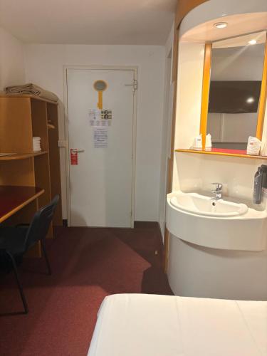 a bathroom with a sink and a mirror at Quick Palace Le Mans in Saint-Saturnin