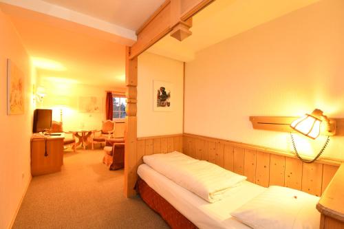 a bedroom with a bed and a lamp in a room at Landhotel Altes Zollhaus in Hermsdorf