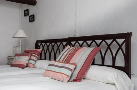 a bed with red and white pillows on it at Olmitos 3, Casa-Palacio Real Piedad in Cehegín
