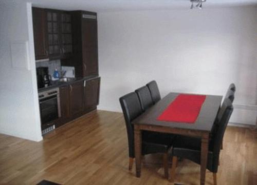 a dining room with a table and chairs and a kitchen at Røldal Overnatting in Røldal