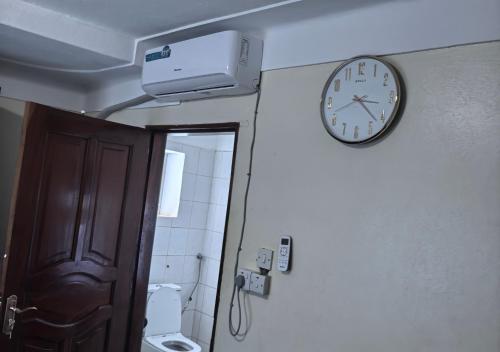 a clock on the wall of a bathroom at Kaa Highway Hotel in Mukono