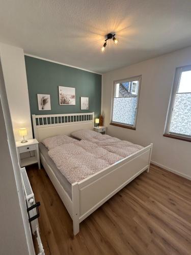 a bedroom with a large bed and two windows at Alte Schmiede Karden in Treis-Karden