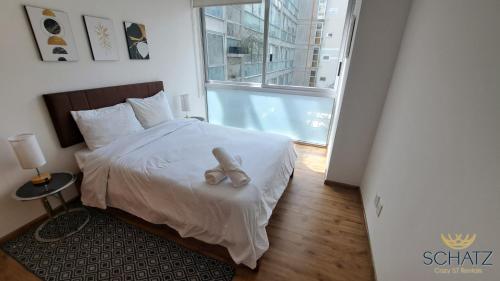 a bedroom with a bed with a teddy bear on it at QBICo Santa Fe Condominium in Mexico City