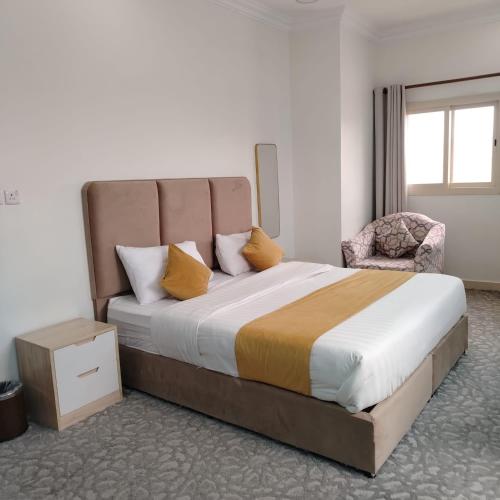 a bedroom with a large bed and a chair at دار الباحة فرع رقم 2 in Al Baha