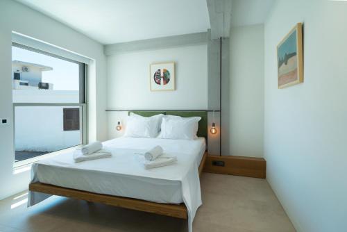 a bedroom with a white bed and a large window at Homey - a living space in Daratso