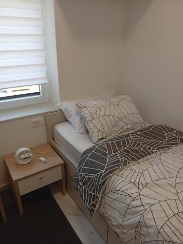 a small bedroom with a bed and a table at Studio apartman Topolovec in Krapina