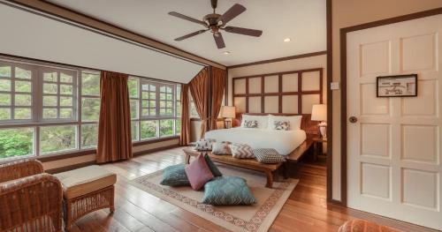 a bedroom with a bed and a couch and a door at Sutera Sanctuary Lodges At Kinabalu Park in Kampong Kundassan