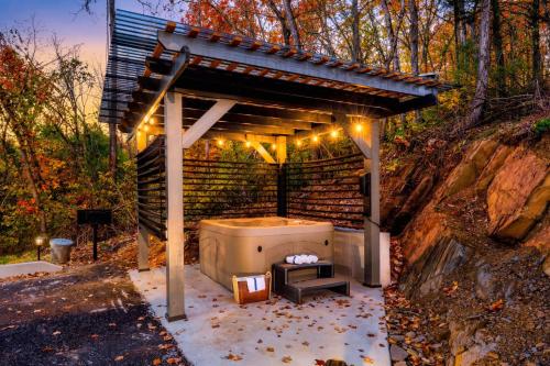 a gazebo with a hot tub in the woods at Open Skydeck with Spectacular View and Hot Tub in Sevierville