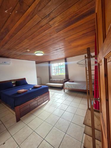 a bedroom with a blue bed and a wooden ceiling at Casa solarte bocas del toro in Bluff BEach