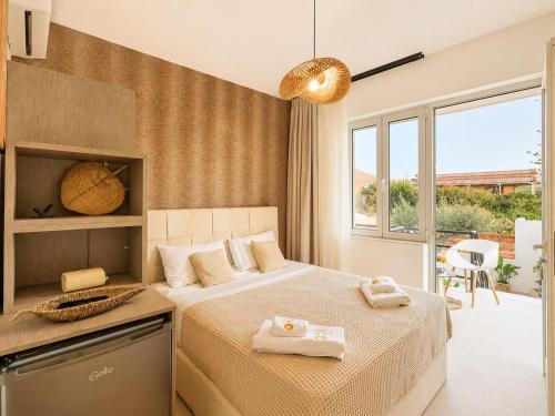 a bedroom with a bed with two towels on it at AVENA Suites in Kato Gouves