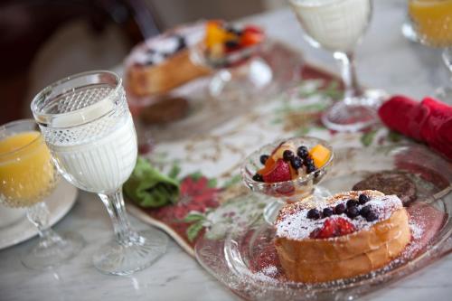 un tavolo con un piatto di cibo e bicchieri di vino di Bradford House Bed and Breakfast a Branson