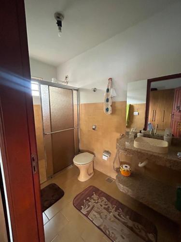 a bathroom with a toilet and a sink and a mirror at Casa da Conceição in Capitólio