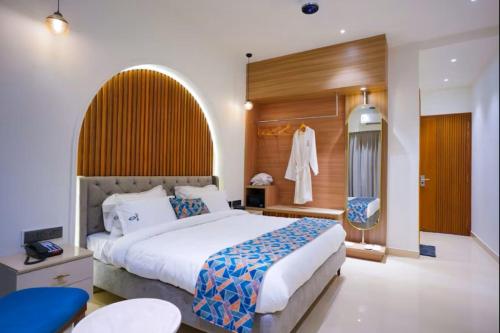 a bedroom with a large bed and a dressing room at The ELET near Amritsar Airport in Amritsar