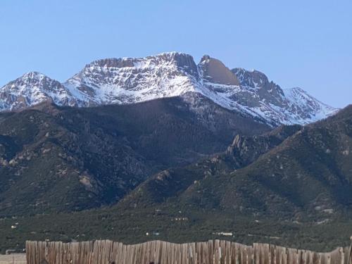 a snow covered mountain with a fence in front of it at The Crestone Hideaway in Crestone