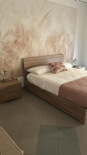 a bedroom with a large bed with a wooden headboard at Casa mediterranea in Formia