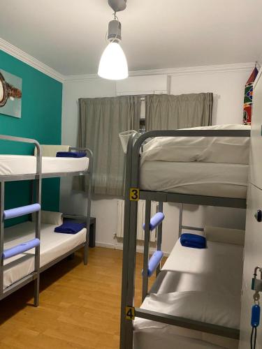 a room with three bunk beds and a light at Valença Guesthouse in Valença