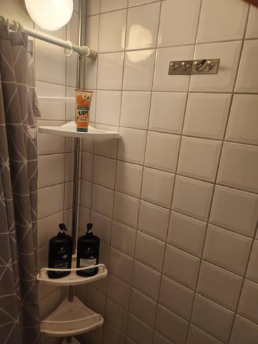 a bathroom with white tiled walls and a shower at Sommarlägenhet i Vadstena in Vadstena