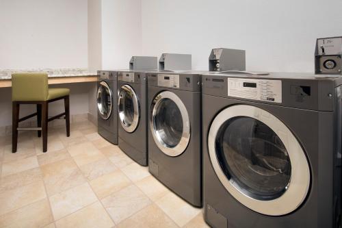 a row of washing machines in a laundry room at Country Inn & Suites by Radisson, Houston Intercontinental Airport East, TX in Humble