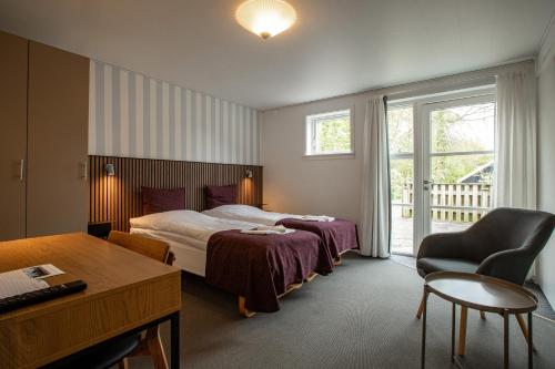 a hotel room with a bed and a desk at Hotel Balka Strand in Neksø