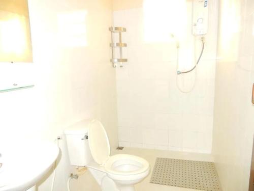 a white bathroom with a toilet and a shower at Camellia Vang Vieng in Vang Vieng