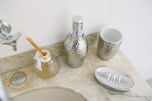 a bathroom counter with a sink and some vases at CLH Suites Domingos Ferreira in Rio de Janeiro