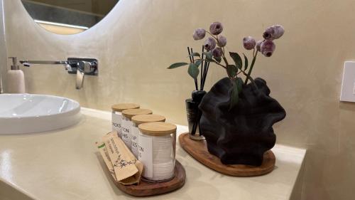 a bathroom counter with a vase with purple flowers in it at Nikola apartman in Arilje