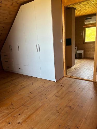 an attic room with white cabinets and a wooden floor at Planinski Kutak in Vareš