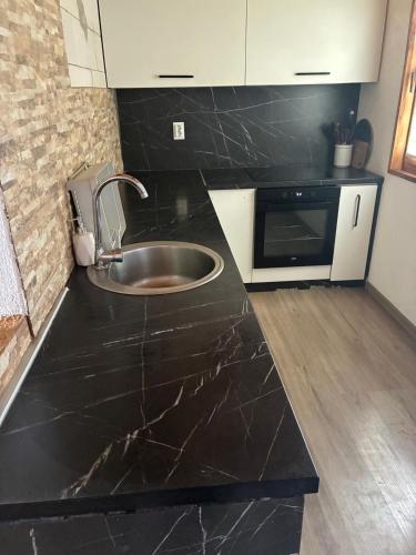 a kitchen with a sink in a black counter top at Planinski Kutak in Vareš