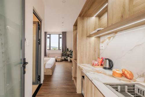 a kitchen with a sink and a bed in a room at DO Hotel in Da Lat